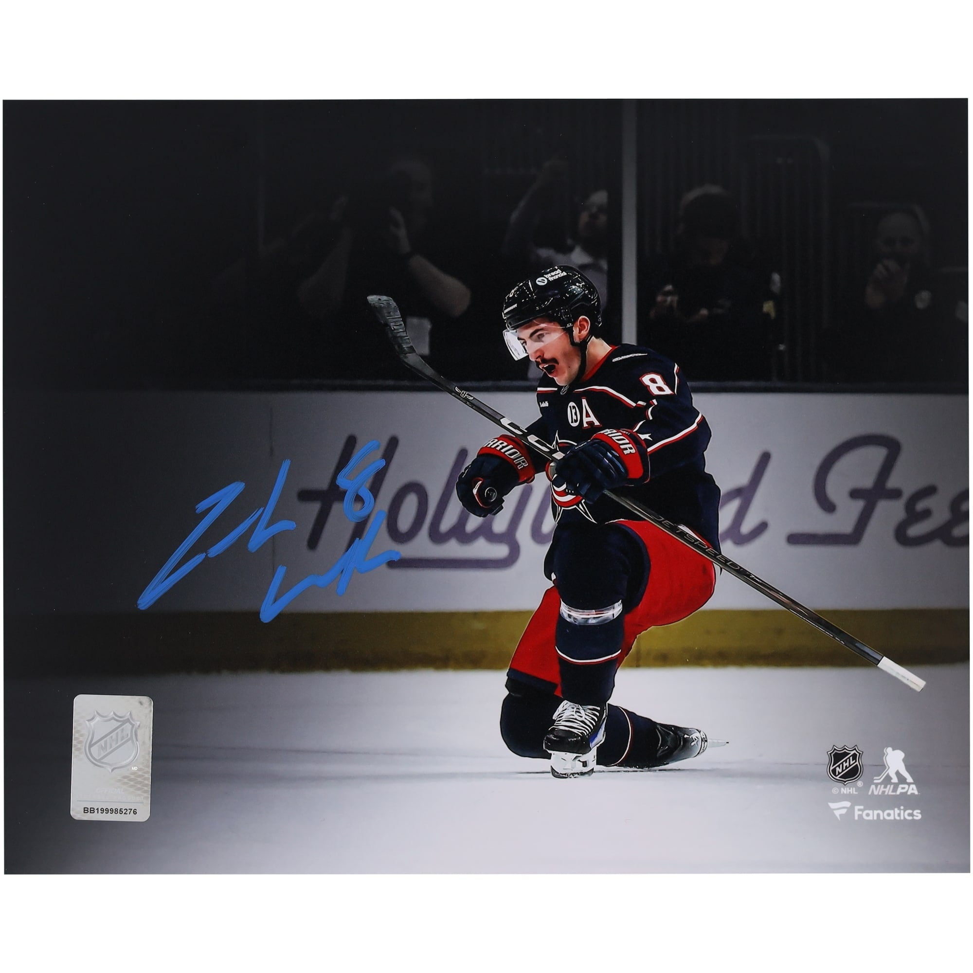 Photo de Zach Werenski, des Blue Jackets de Columbus, autographié au format 8 x 10 pouces (20 x 25 cm), maillot bleu marine, lors de sa célébration.