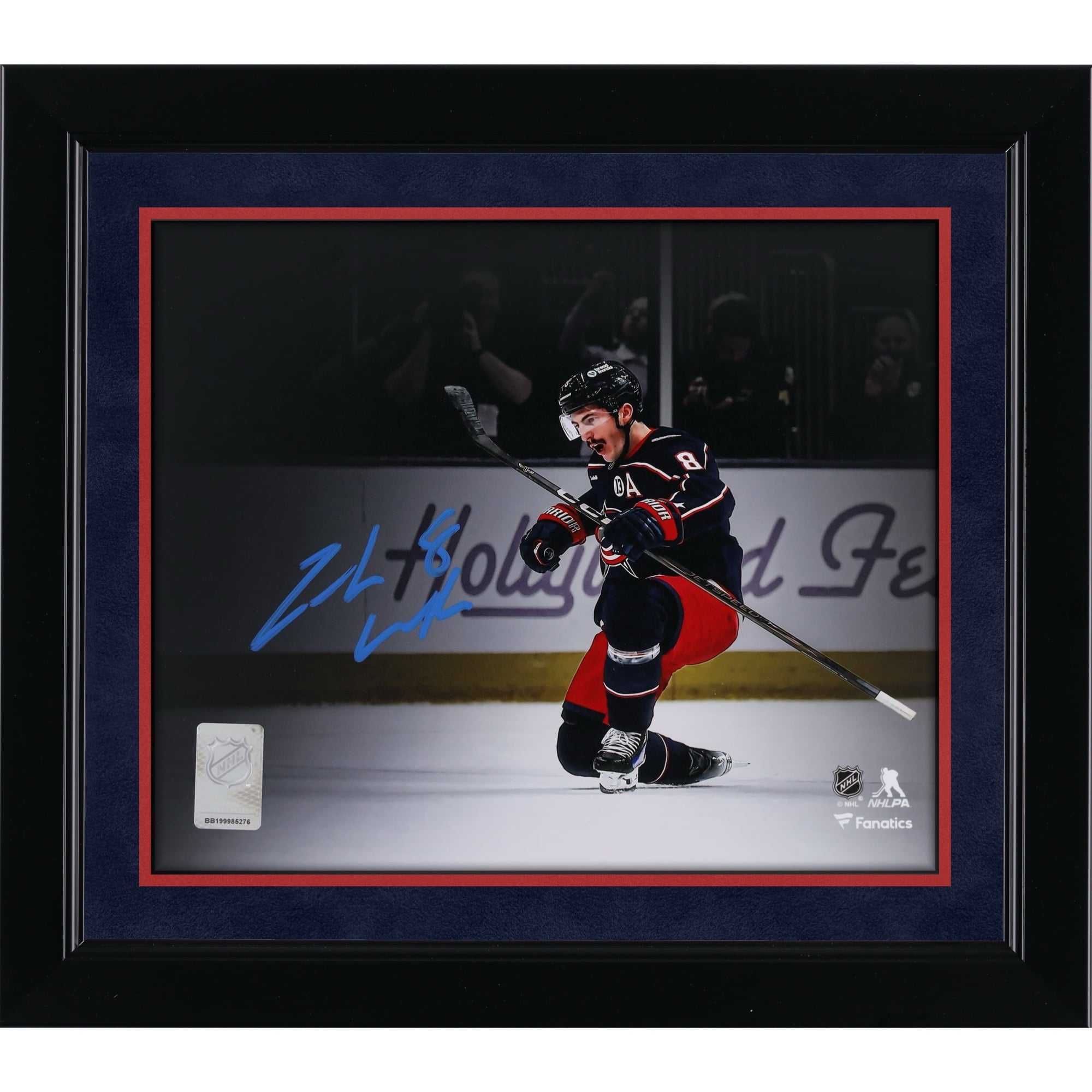 Photo de Zach Werenski, des Blue Jackets de Columbus, autographié au format 8 x 10 pouces (20 x 25 cm), maillot bleu marine, lors de sa célébration.