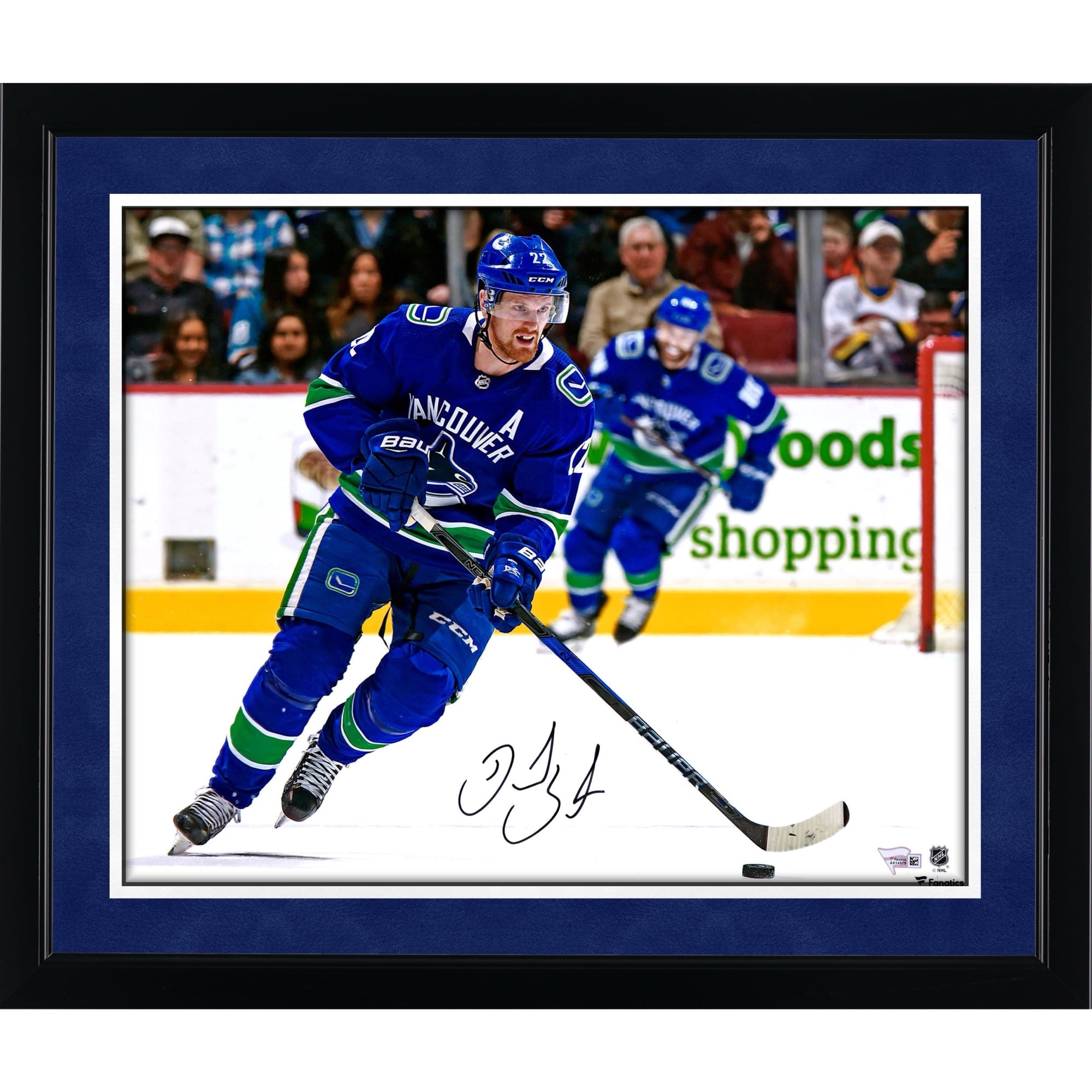 Photo de patinage autographiée de Daniel Sedin, joueur des Canucks de Vancouver, en maillot bleu (16 po x 20 po).